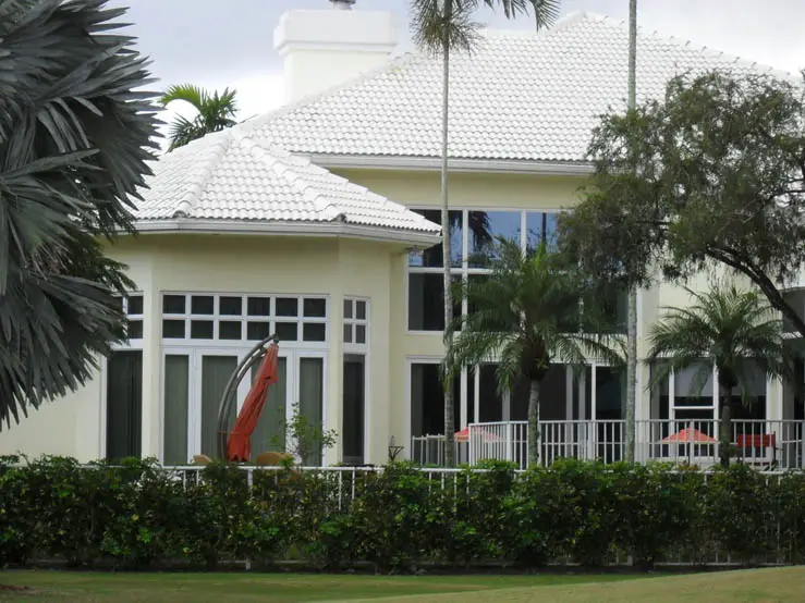 yellow house with white roof and new impact windows doors