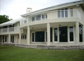 impact windows protect your home | backyard of two story house with various impact windows and impact doors