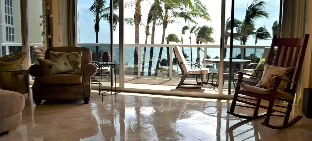 interior of living room facing out towards the ocean in south florida with hurricane windows half open